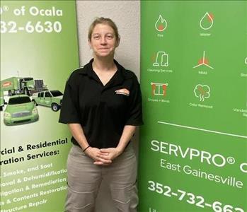 Rose Standing in front of two SERVPRO green banners