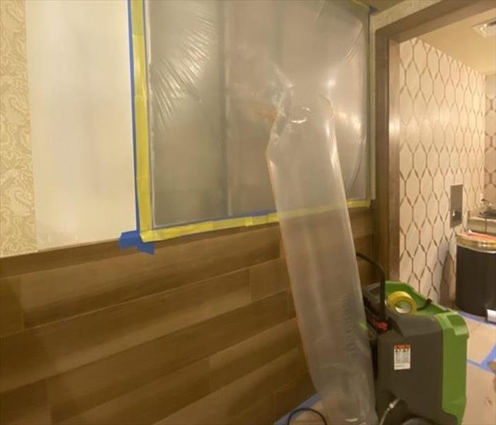 Dehumidifier blowing hot air into wall cavity