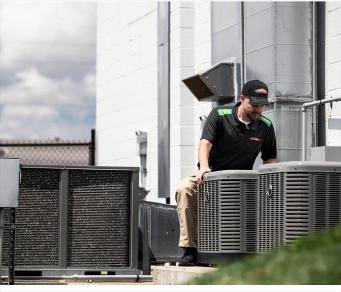 SERVPRO Professional inspecting commercial air conditioning units