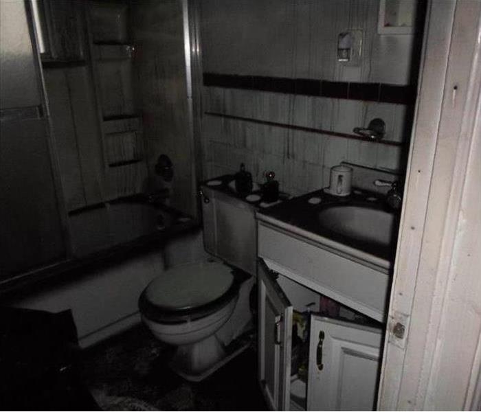 A bathroom filled with soot and water damage after a fire