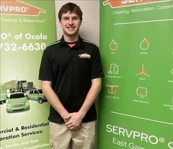 Roy standing in front of two green SERVPRO banners