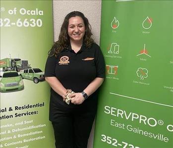 Alli standing in front of two SERVPRO green banners